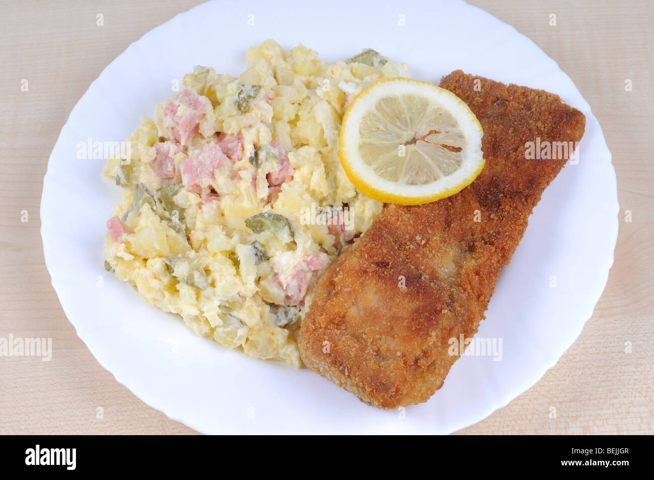 Weißen Teller mit gebratenen panierten Karp mit Kartoffelsalat. Stockfoto