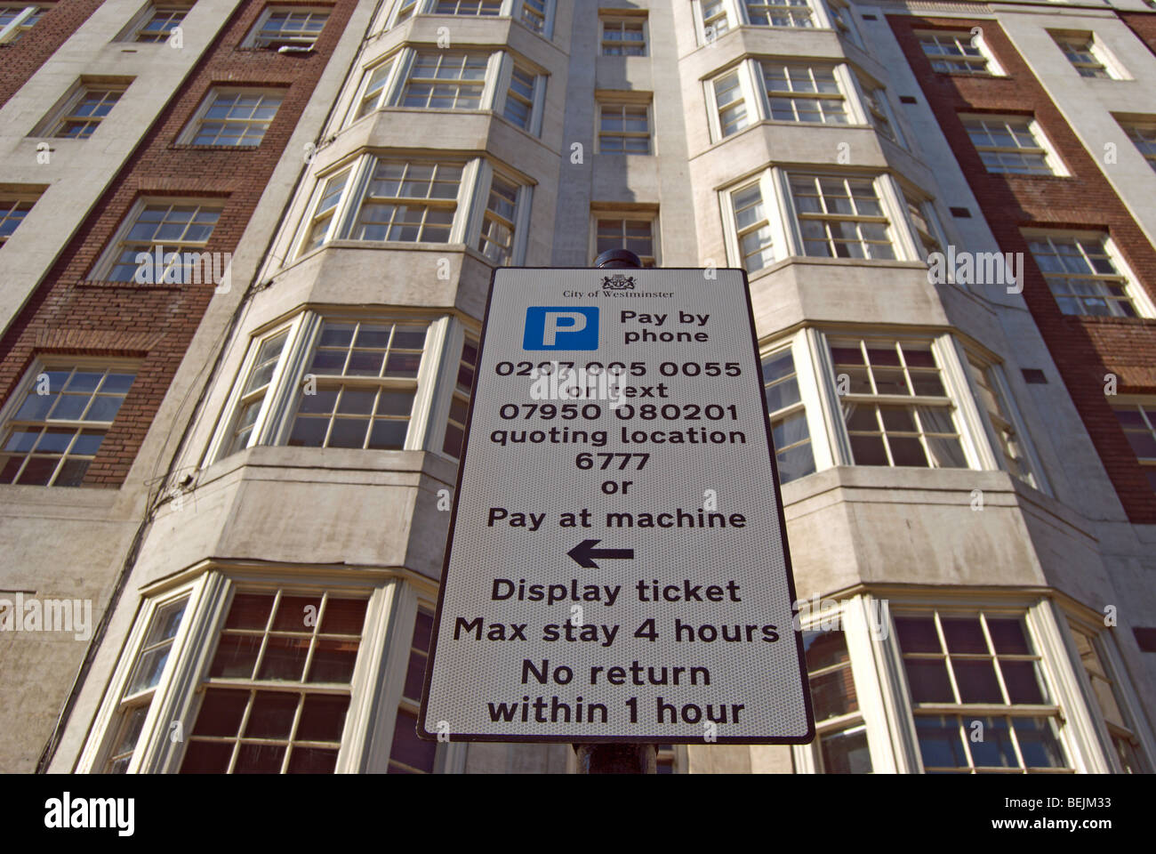 Zahlen und Verkehrszeichen mit örtlichen Vorschriften auf Queensway, London, England, mit Wohnblock im Hintergrund anzeigen Stockfoto