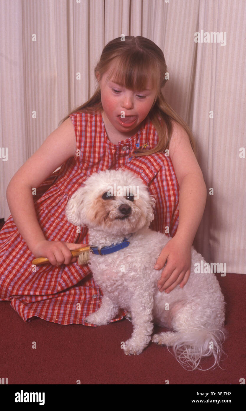 kleines Mädchen mit Down-Syndrom Pflege ihres Hundes Stockfoto