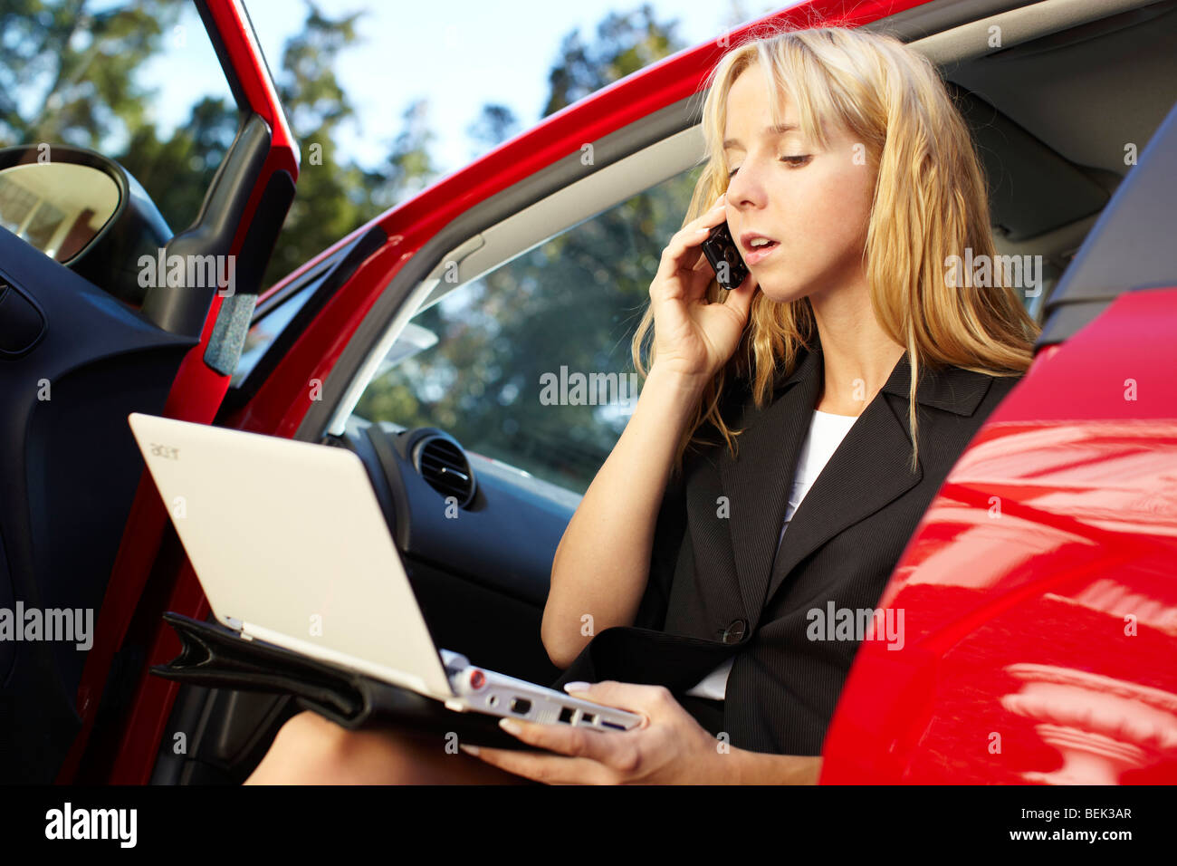 Frau saß im Auto mit laptop Stockfoto