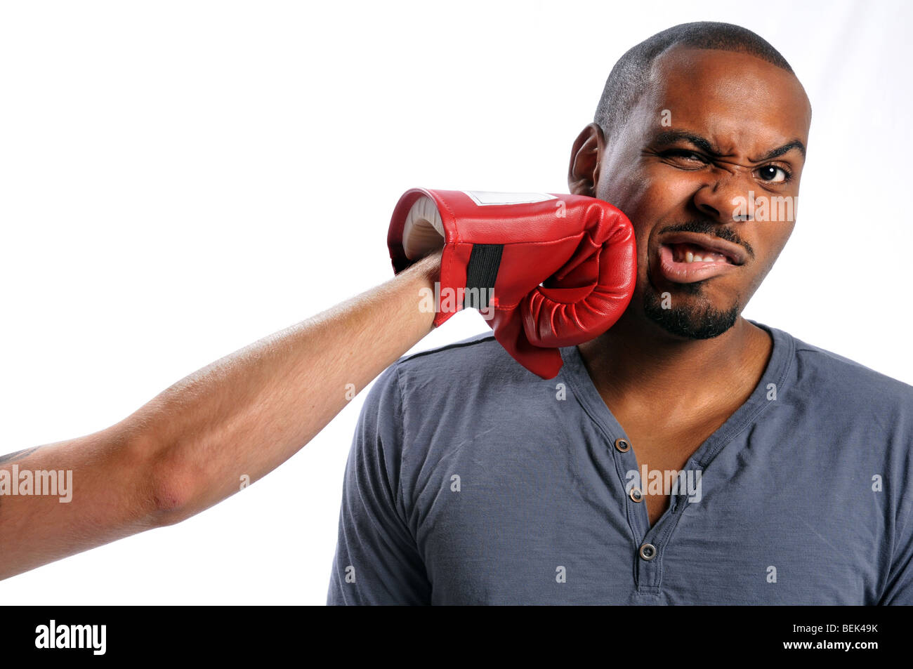 Afrikanische amerikanische Mann auf Gesicht von behandschuhten Hand getroffen Stockfoto