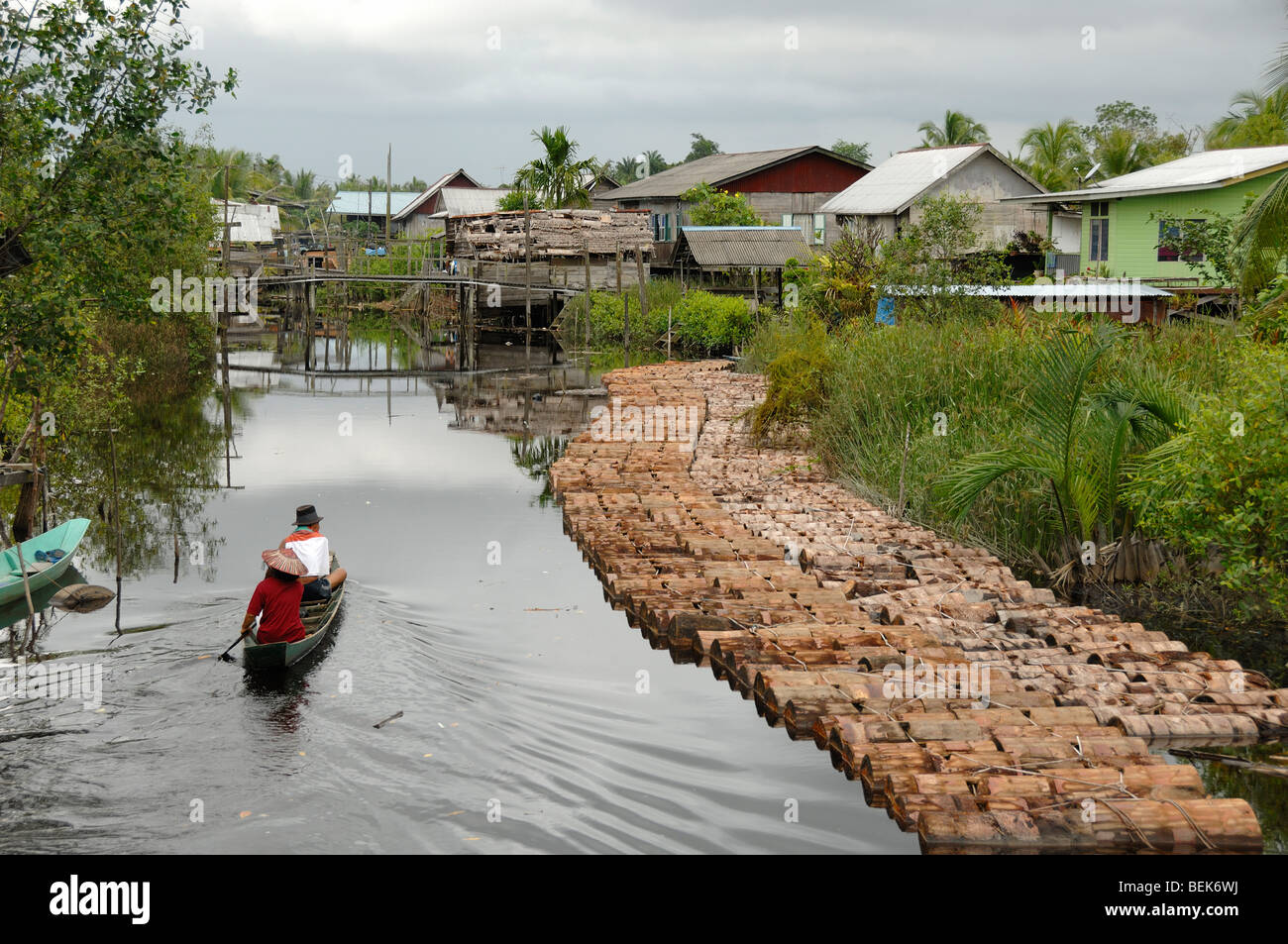 Schneiden Sie Sago-Protokolle und Kanu im River an die Melanau Tellian Kampung oder Stelzenläufer Dorf in der Nähe von Mukah Sarawak Malaysia Borneo Stockfoto