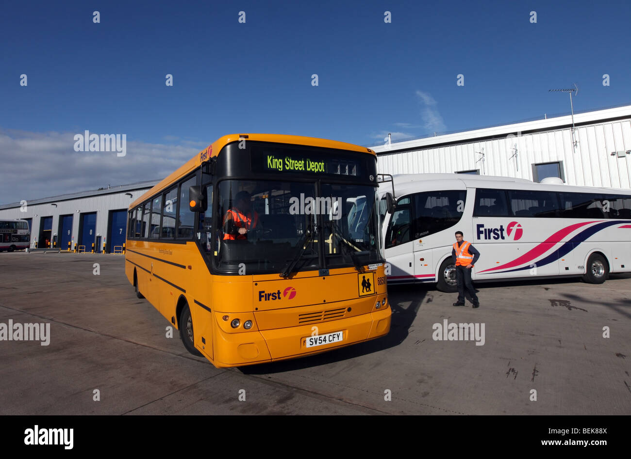 Gelber Schulbus und Coach bei Transport Unternehmen erste Busdepot und Hauptsitz in Aberdeen, Scotland, UK Stockfoto