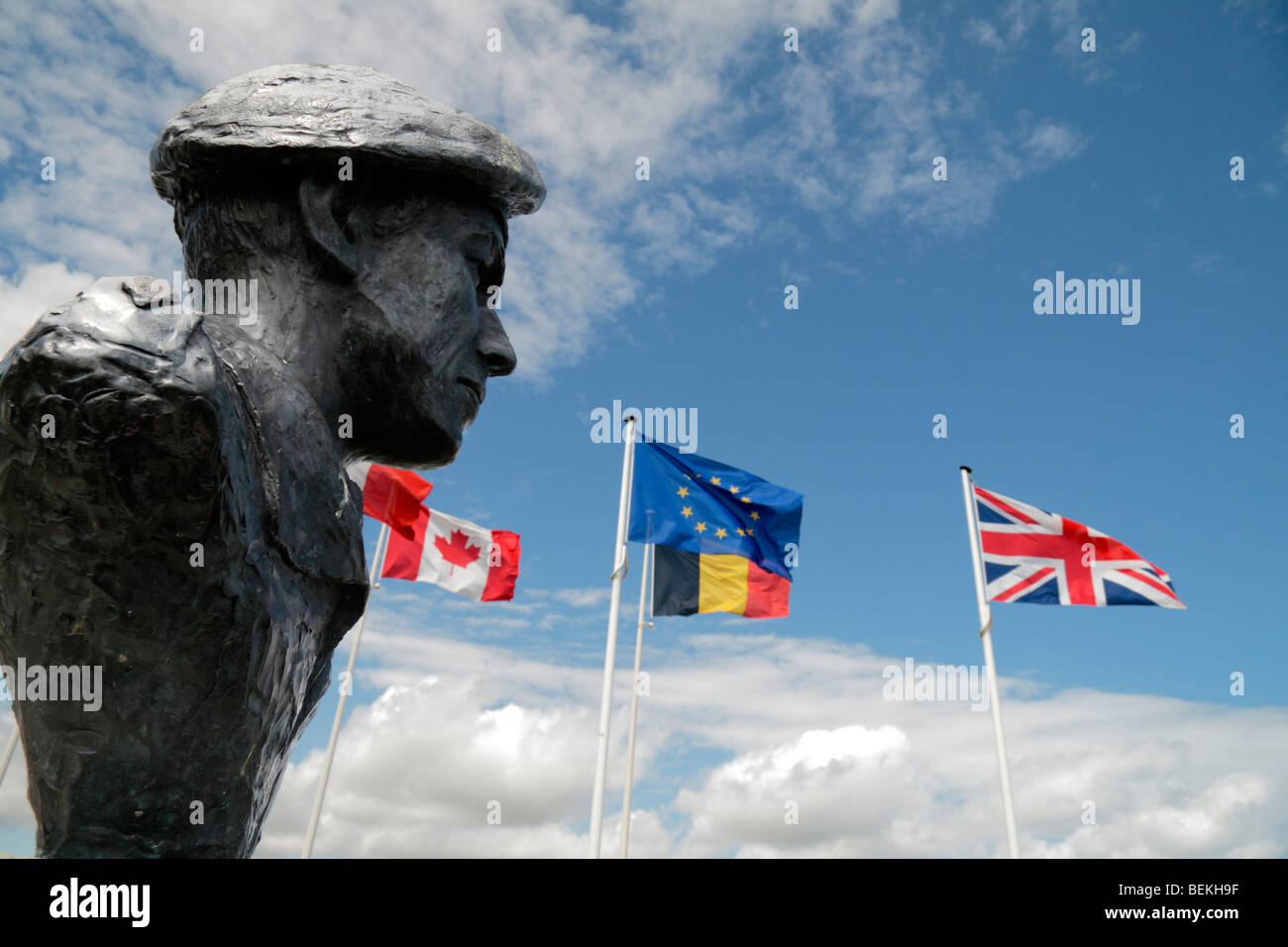 Die EU und Weltkrieg zwei Flaggen wehen neben der Büste, Oberstleutnant T Otway an der Deutsch-Batterie Merville, Normandy. Stockfoto