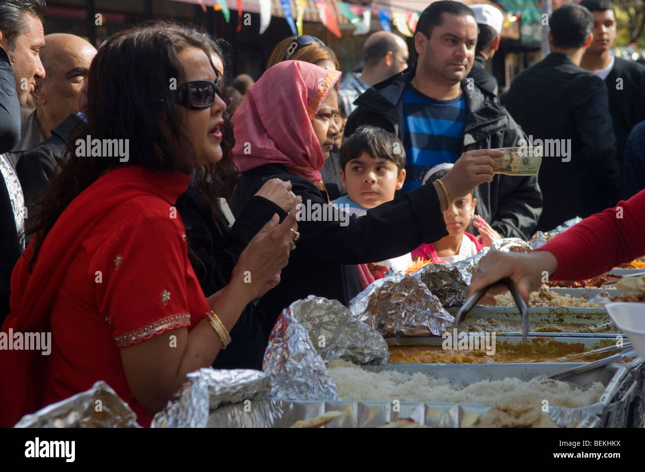 Kunden warten auf indisches Essen bezahlen, während indische Amerikaner und andere Besucher Diwali auf einer Straße Messe in New York feiern Stockfoto
