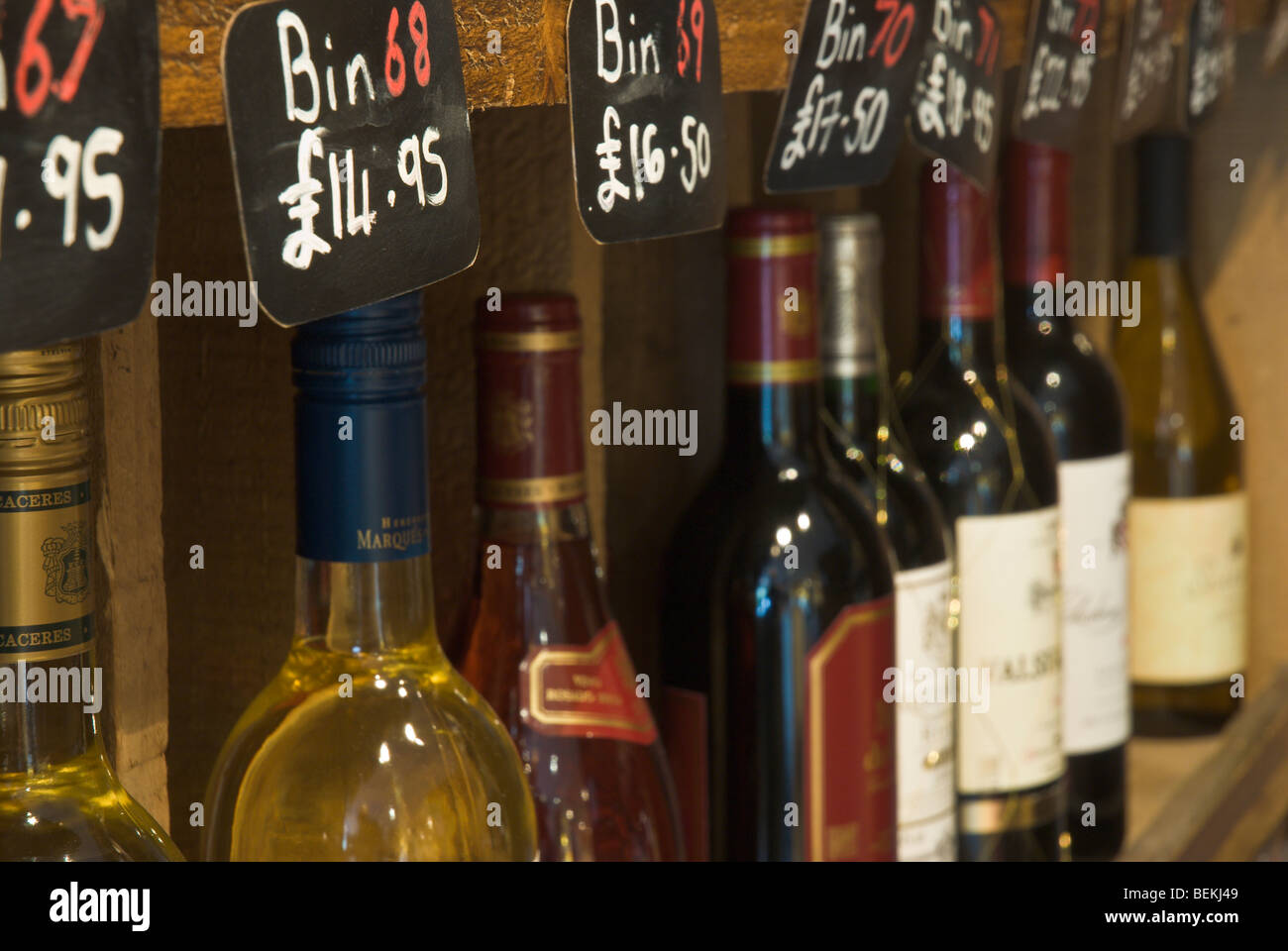 Weinflaschen mit Bin Artikelnummern und Preise in einem Weinregal Stockfoto