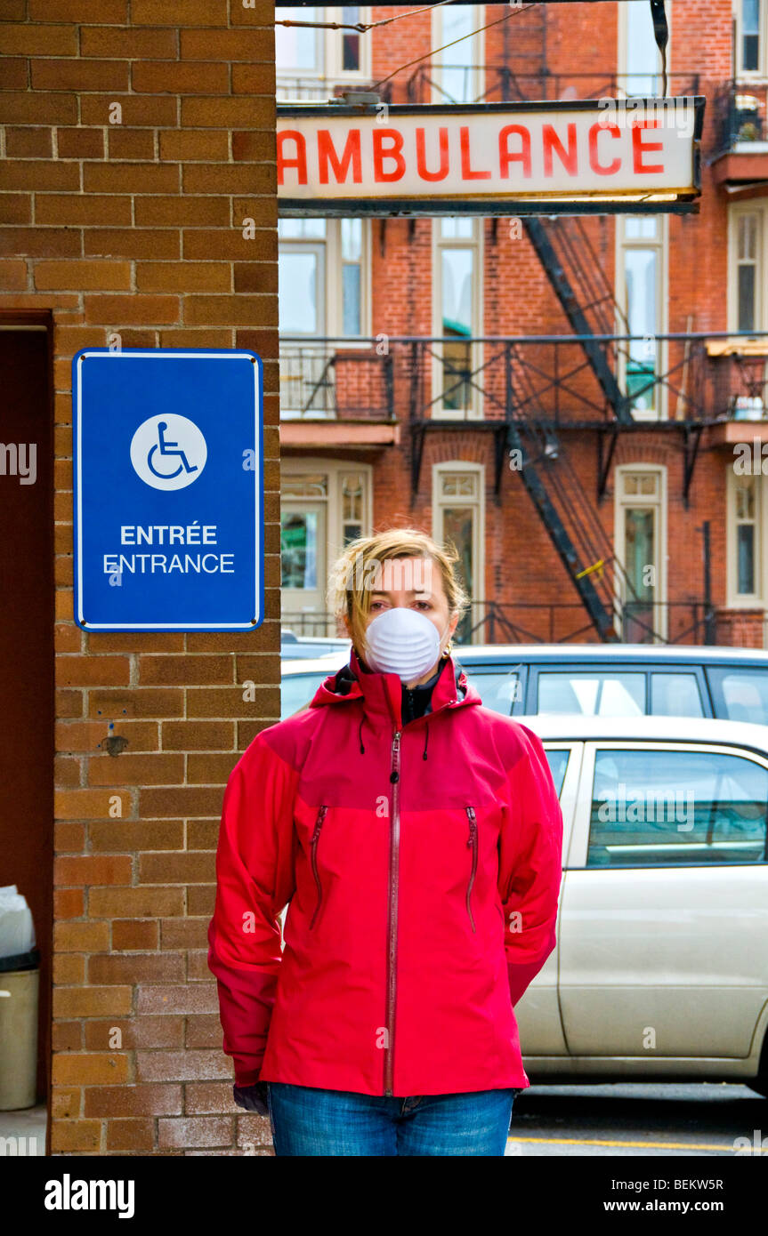Frau vor Krankenwagen Eingang trägt eine Maske zum Schutz gegen Stockfoto