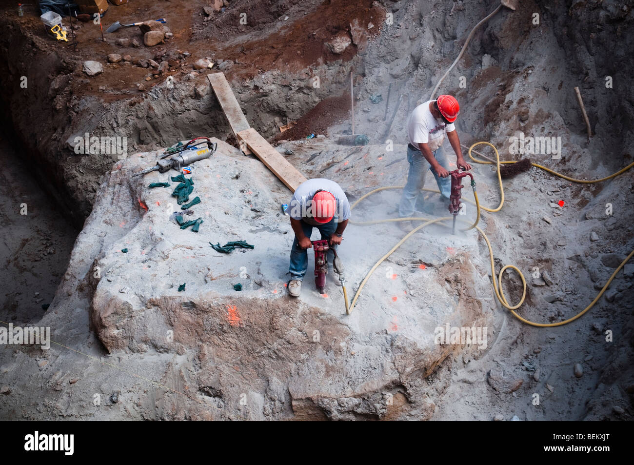 Zwei Bauarbeiter verwenden Presslufthämmer, Rock auf Baustelle auszugraben Stockfoto