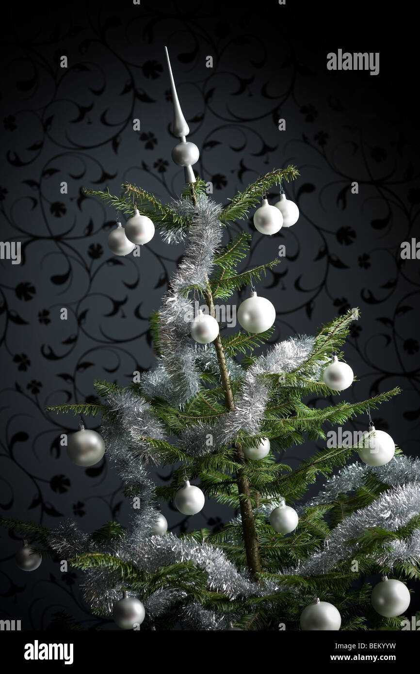 Silber schmückten Tanne Weihnachtsbaum mit Kugeln und Ketten, schwarze Tapete im Hintergrund Stockfoto