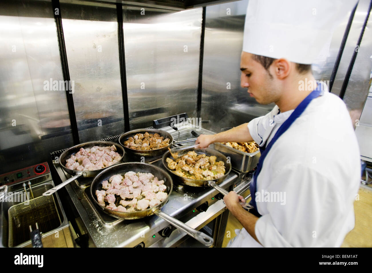 Innere einer Küche mit einem jungen Koch bei der Arbeit, Messe Salone del Gusto, Turin, Piemont, Italien Stockfoto