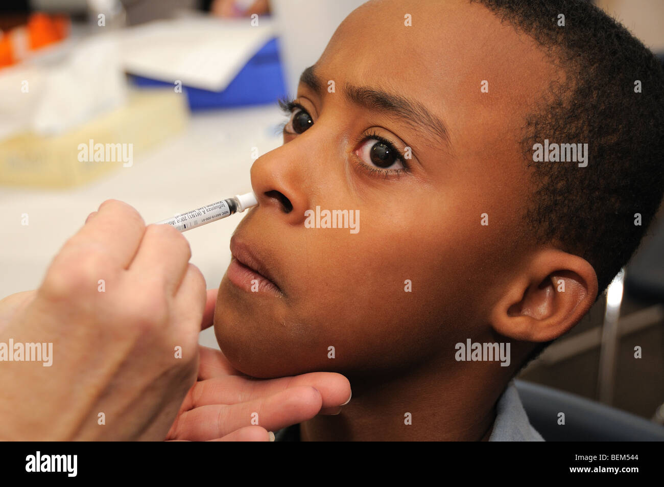 Ein 10-Jahr-alte Junge ist für die 2009 H1N1 Influenza, auch bekannt als die Schweinegrippe, mit einem intranasalen Impfstoff geimpft. Stockfoto