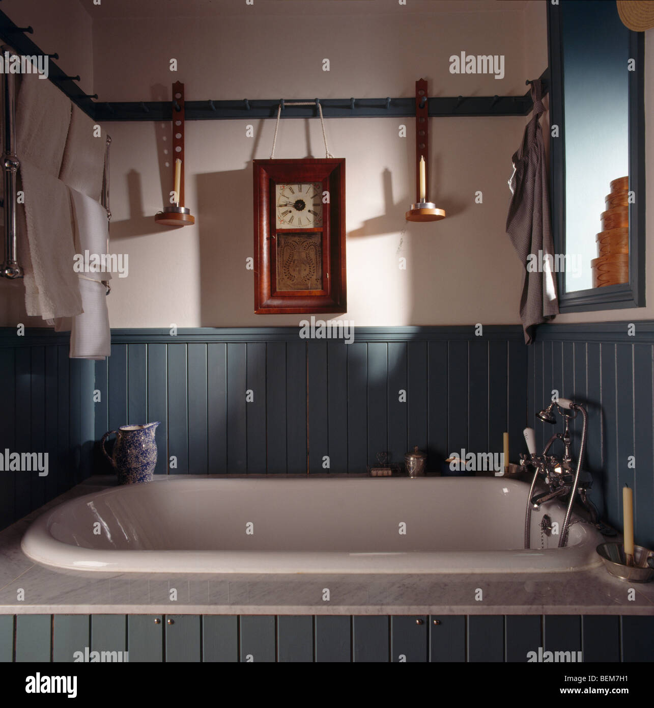 Holzrahmen Uhr unterbrochen von der Schiene über weiße Bad im grünen  Dado-getäfelten Shaker-Stil Badezimmer Stockfotografie - Alamy