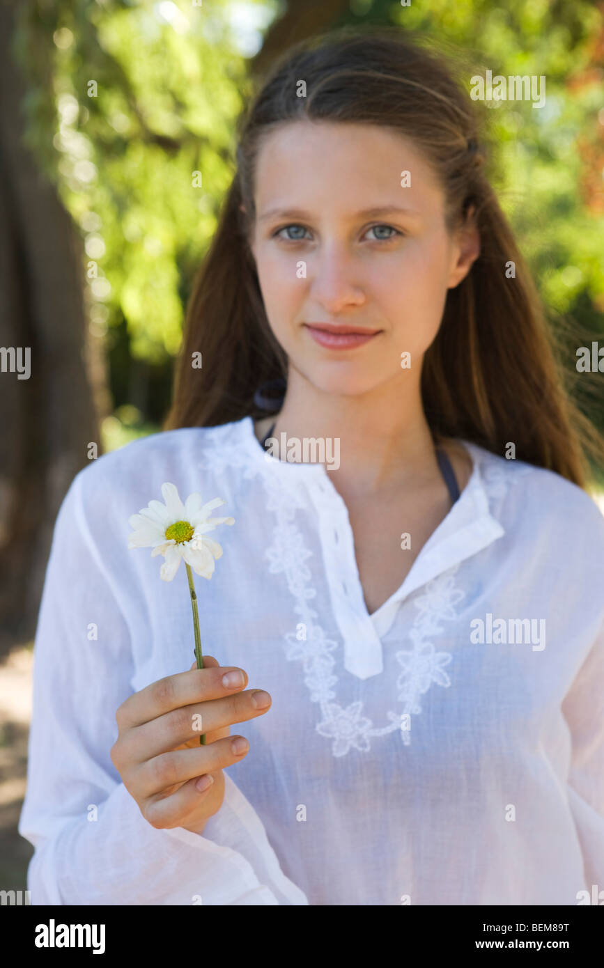 Junge Frau Holding Blume, Porträt Stockfoto