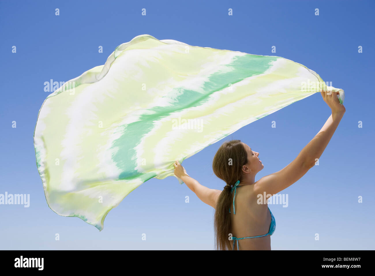 Junge Frau halten Schal im Wind Stockfoto