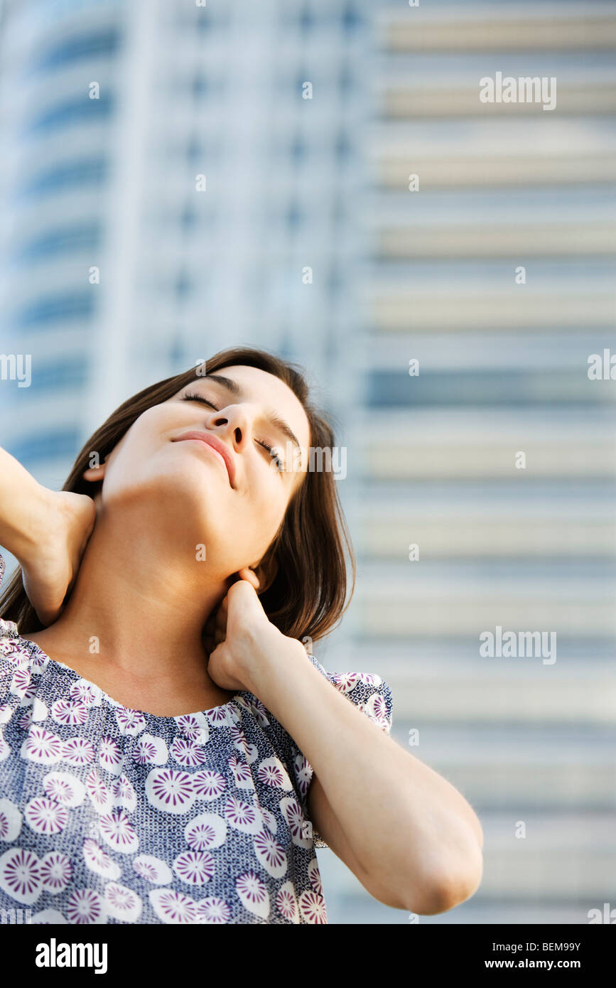 Frau massiert ihren Hals, Augen geschlossen Stockfoto