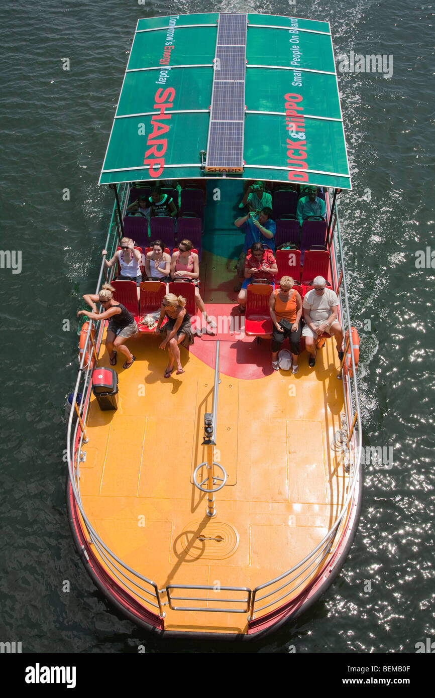 Ein Ausflugsschiff am Singapore River. Boot hat Werbung Sharp Solarpanels auf dem Dach. Stockfoto