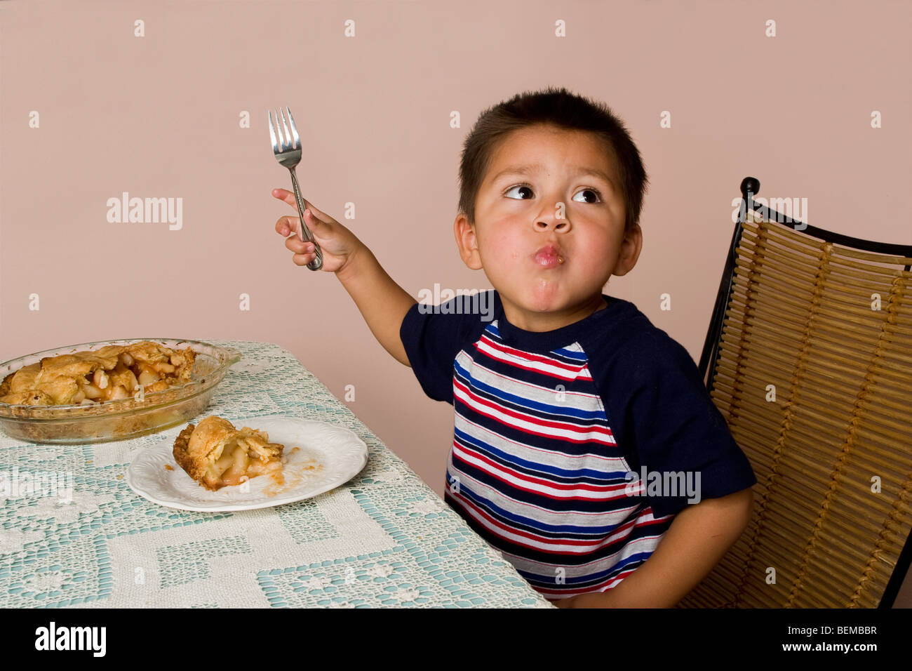 3-4 Jahre alten Hispanic junge Essen Apfelkuchen am Tisch Mund voll, oben zu schauen. Kalifornien HERR © Myrleen Pearson Stockfoto