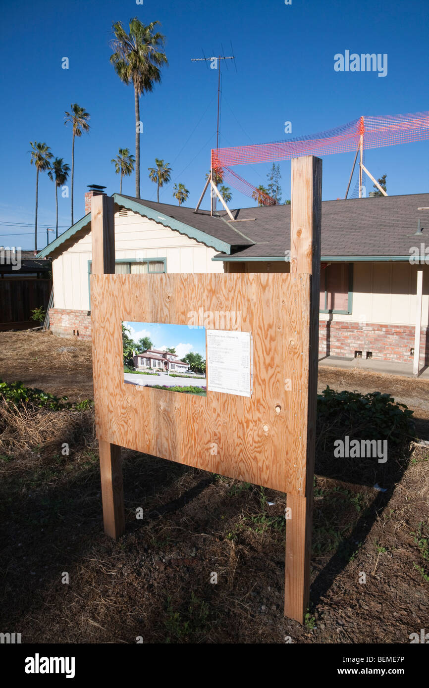 Ein Schild zeigt Details zu einem Einfamilienhaus Neubauprojekt mit dem alten Haus im Hintergrund. California Stockfoto