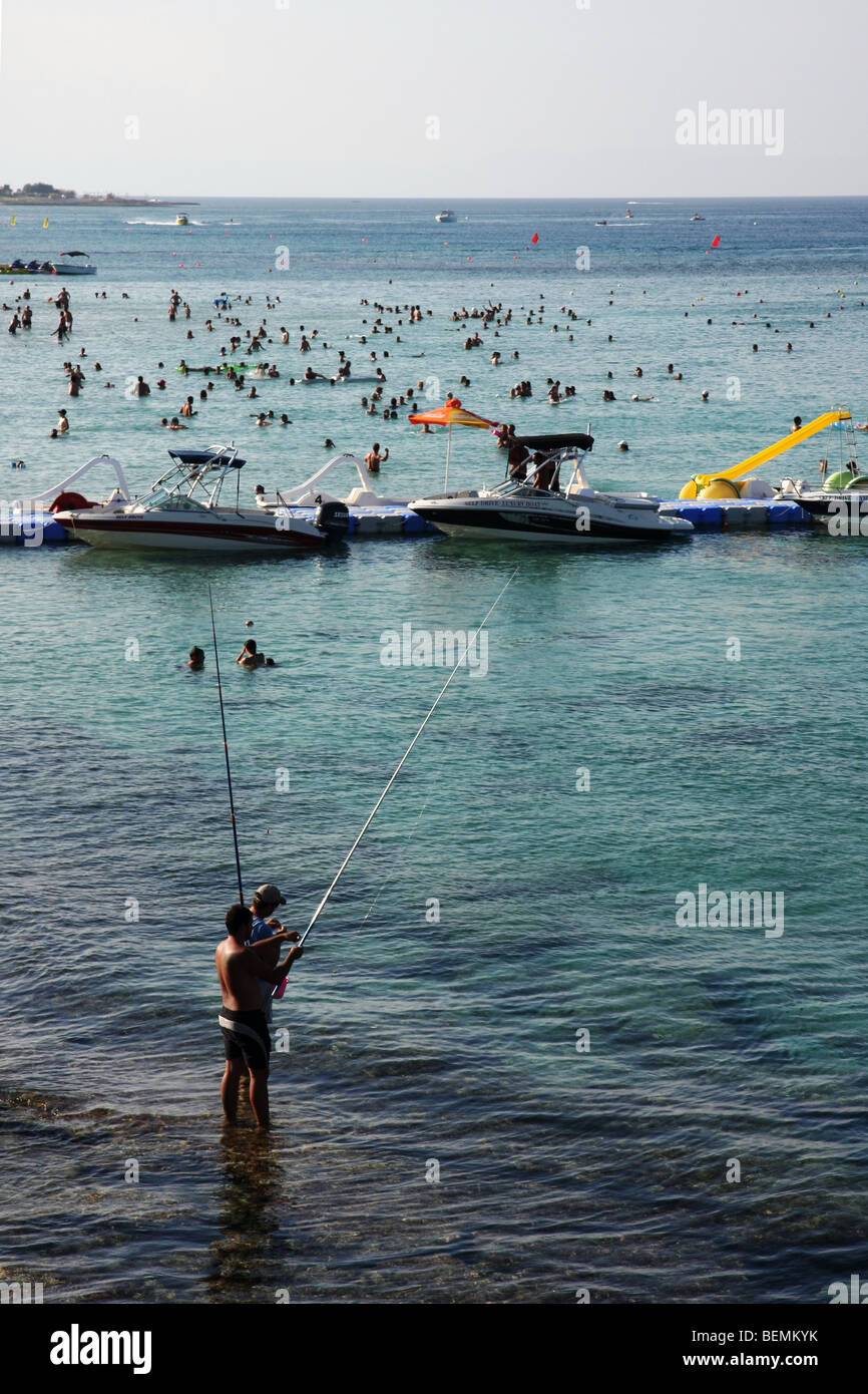 Zwei Männer Angeln am Strand von Fig Tree Bay, Protaras, Zypern. Stockfoto