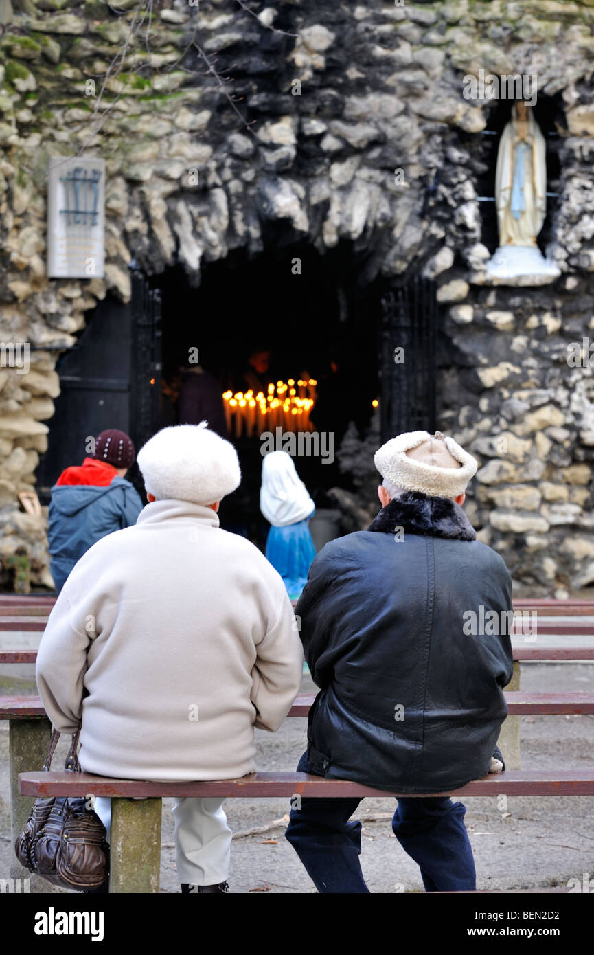 Menschen beten an der Lourdes-Grotte, Oostakker Lourdes Wallfahrtsort in der Nähe von Gent, Ost-Flandern, Belgien Stockfoto
