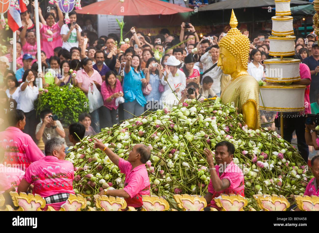 Massen werfen Lotusblumen auf eine Buddha-Statue auf dem Rap Bua Lotus werfen Festival in Thailand feiert das Ende der buddhistischen Stockfoto