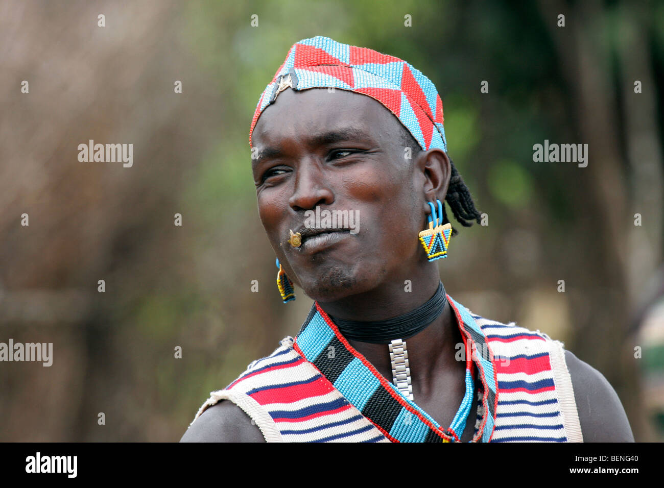Mann von der Bana / Bena Stamm in traditioneller Tracht tragen bunte Perlen in Schlüssel Ferne, Äthiopien, Südafrika Stockfoto