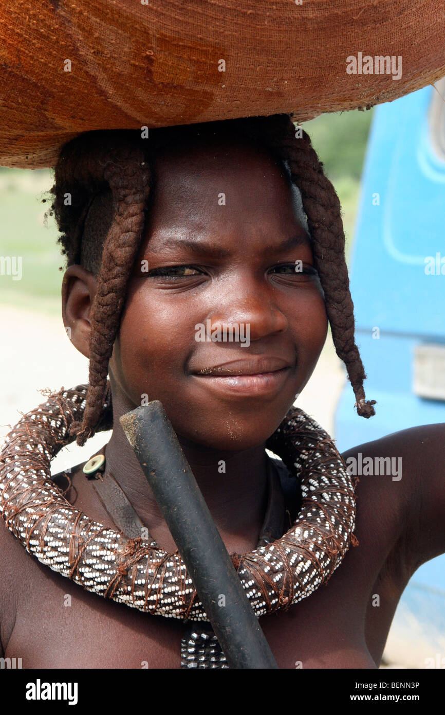 Himba-Frau, die die Ware auf dem Kopf, Kaokoland / Kaokoveld, Kunene-Region, nördlichen Namibia, Südafrika Stockfoto