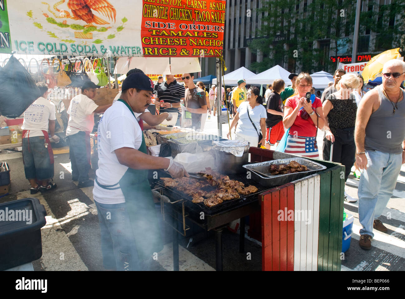 Koch bereitet gegrilltes Fleisch an einem Stand verkaufen mexikanisches Essen an einer Straßenecke fair in New York Stockfoto