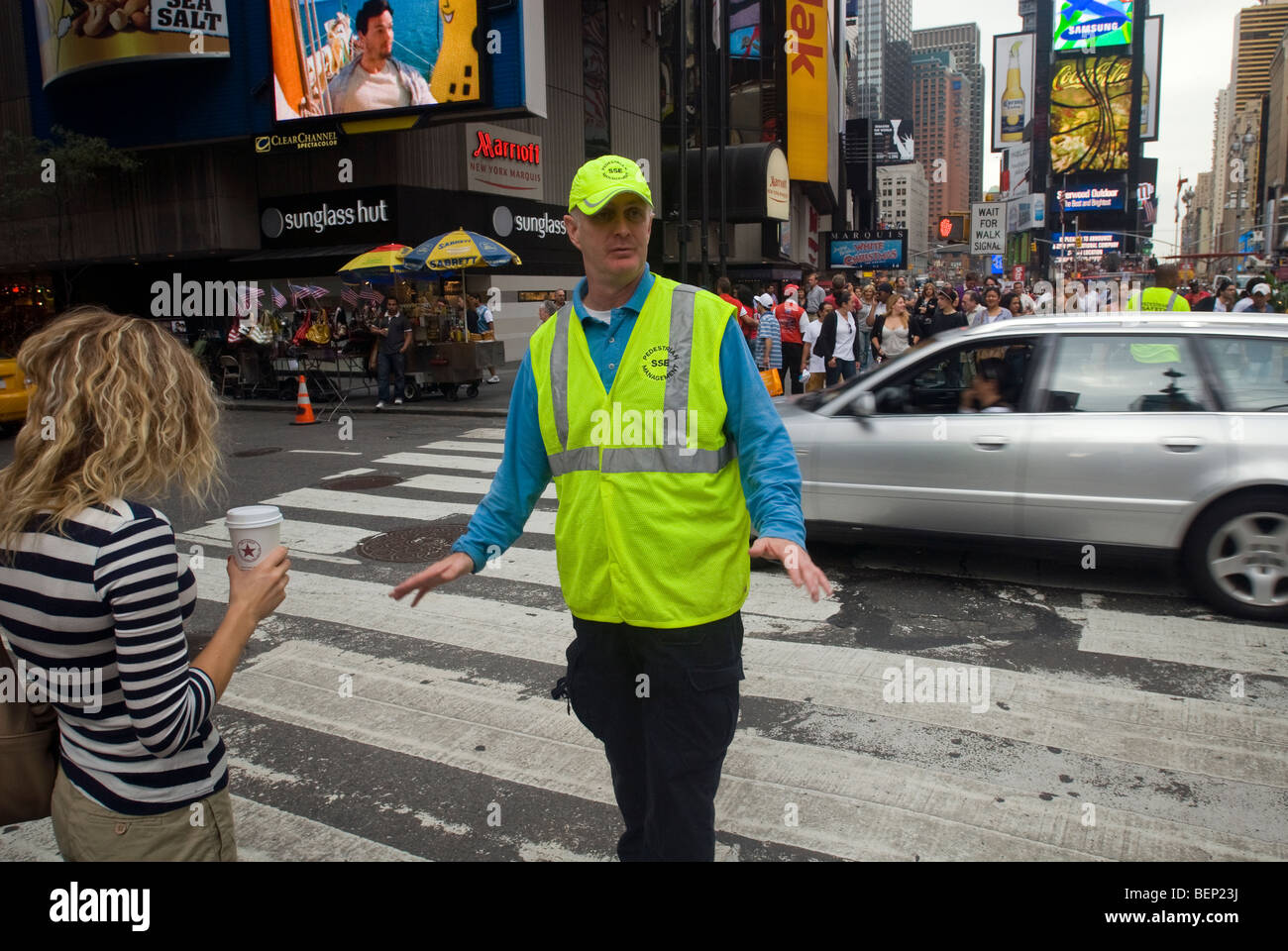 Ein Fußgänger Sicherheitsbeauftragter lenkt die Massen auf dem Times Square in New York Stockfoto