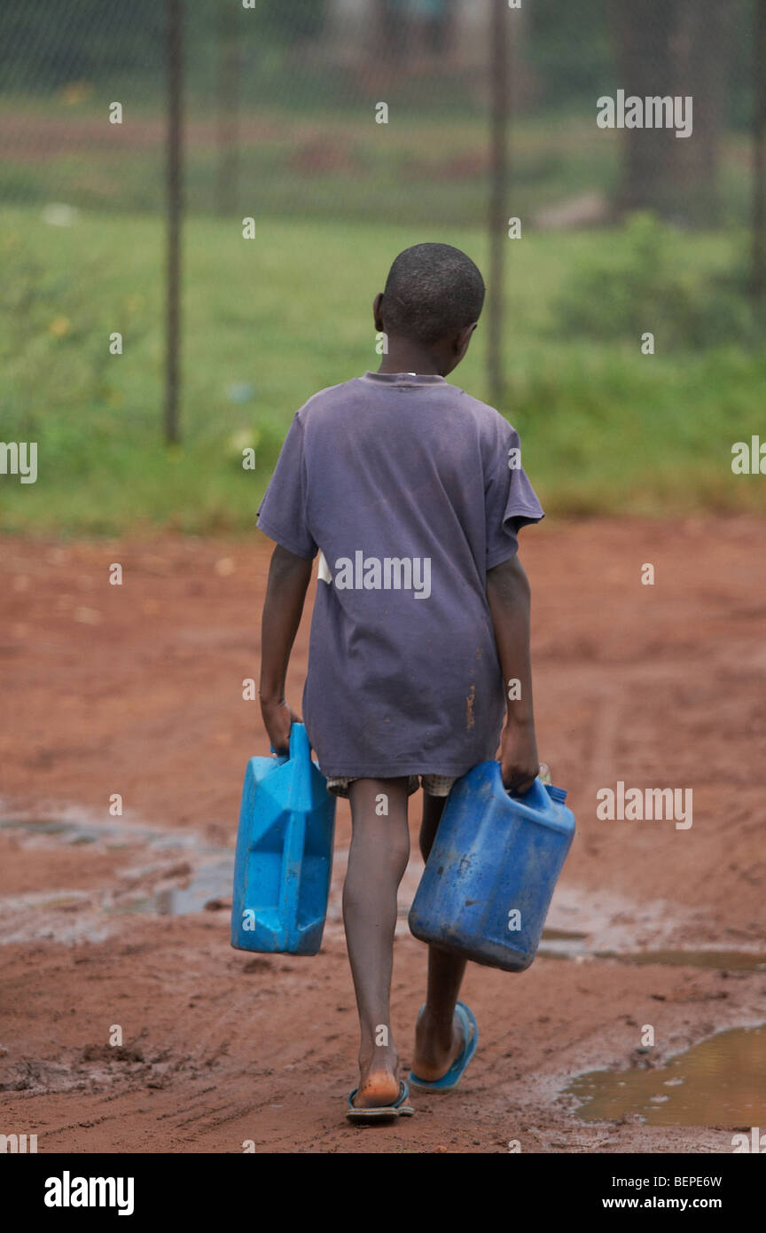 UGANDA-Boy Wassertragen. Dorf von Kayunga Bezirk Foto von SEAN SPRAGUE Stockfoto