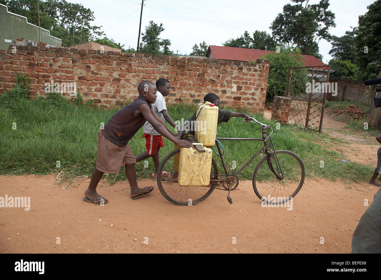 UGANDA-Boys Wassertragen, Mukono District. Foto: SEAN SPRAGUE Stockfoto