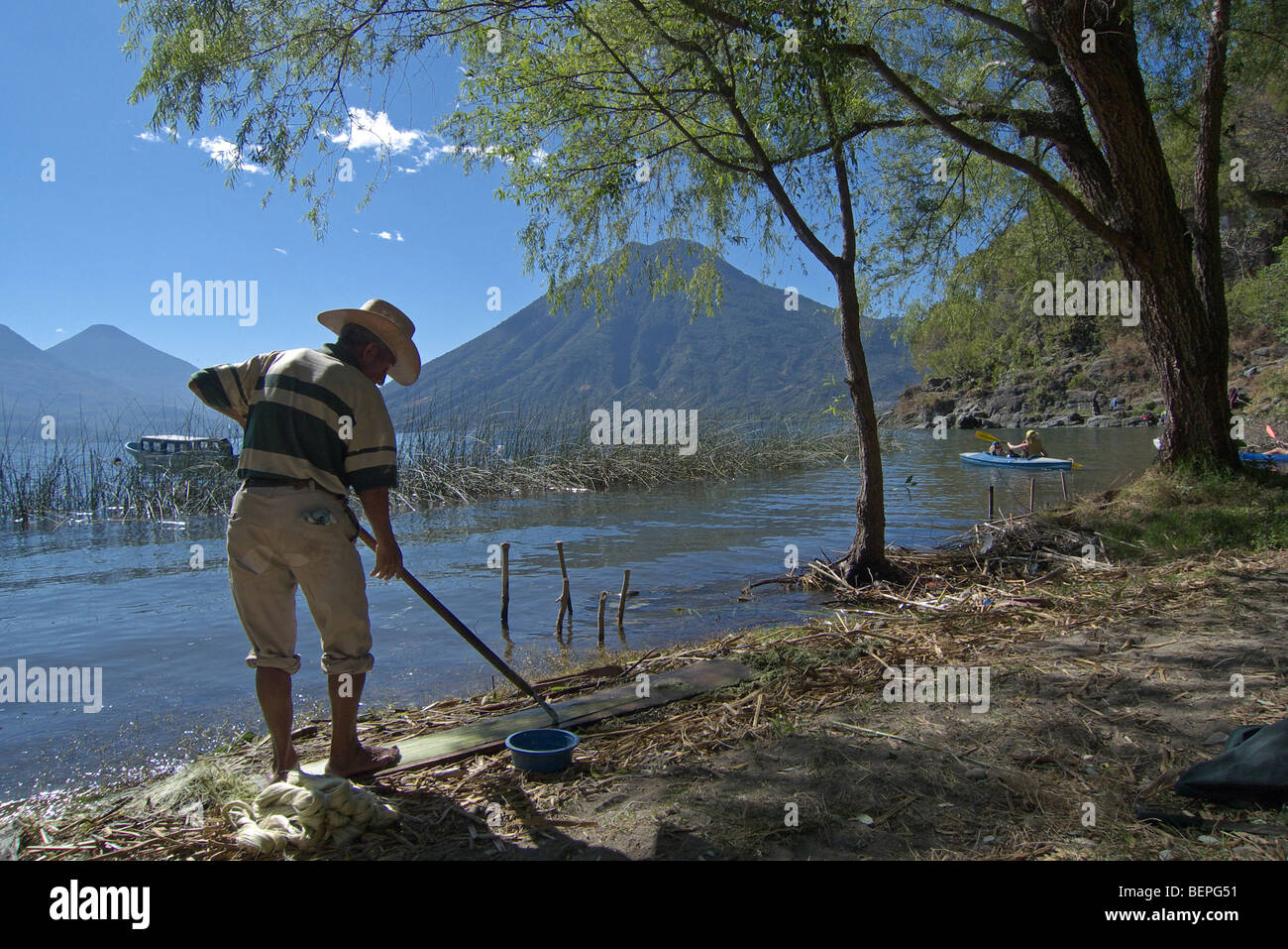 GUATEMALA-Mann Reinigung Müll vom Strand San Marcos la Laguna Lake Atitlan. Foto: SEAN SPRAGUE 2009 Stockfoto