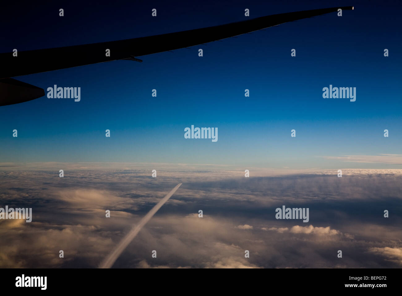 Flugzeugflügel vor einem dramatischen Sonnenuntergang Dämmerung Himmel Stockfoto