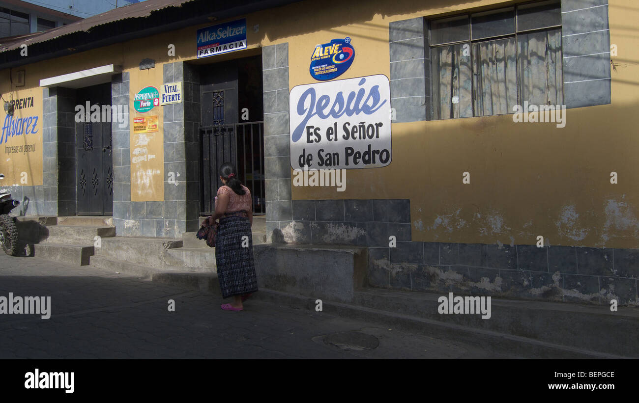 GUATEMALA San Pedro la Laguna Lake Atitlan. Frauen gehen vorbei an evangelischen Schild: Jesus ist der Meister von San Pedro. FOTO VON MEER Stockfoto