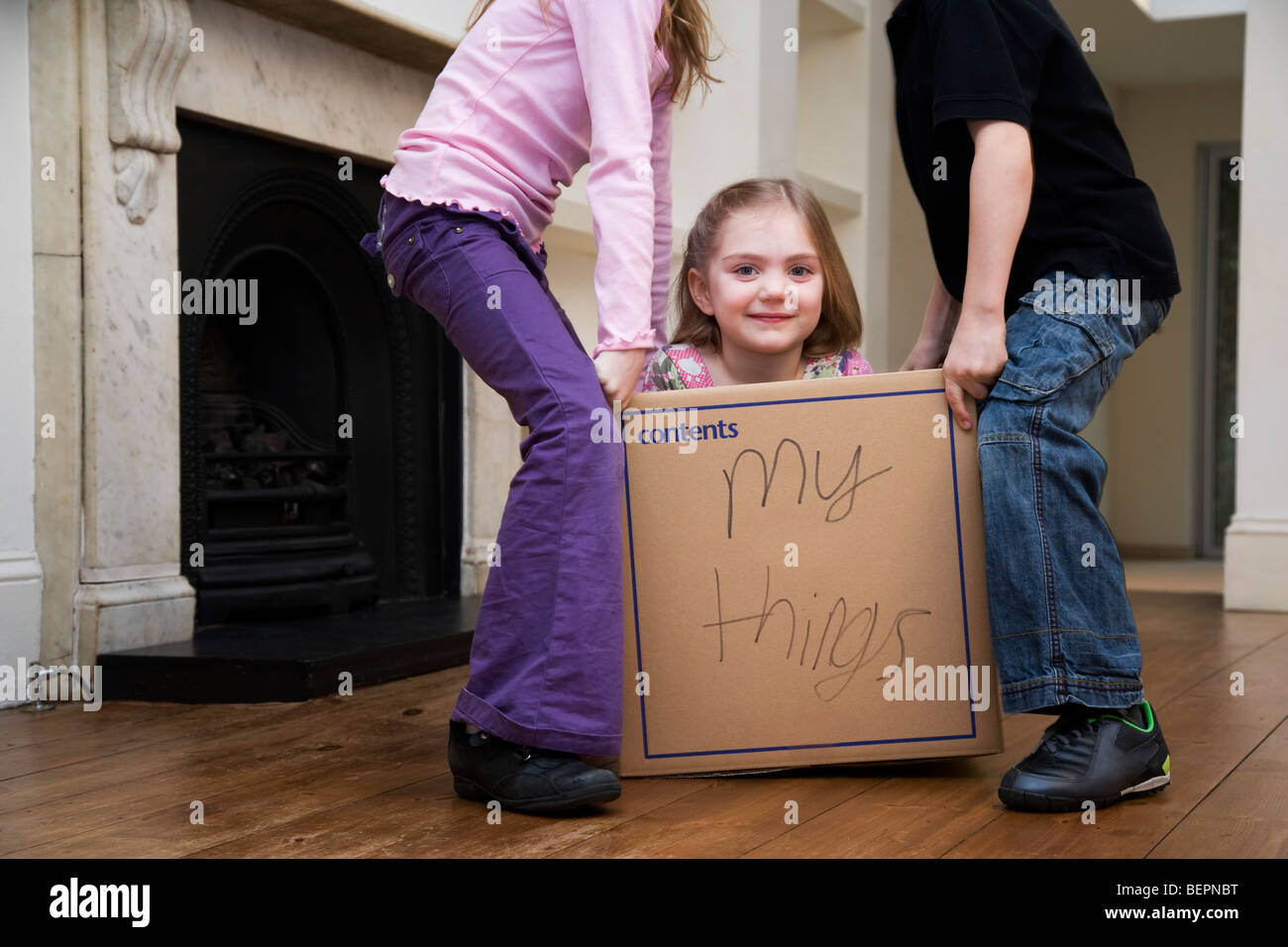 Zwei Kinder, ein weiteres Kind heben Stockfoto