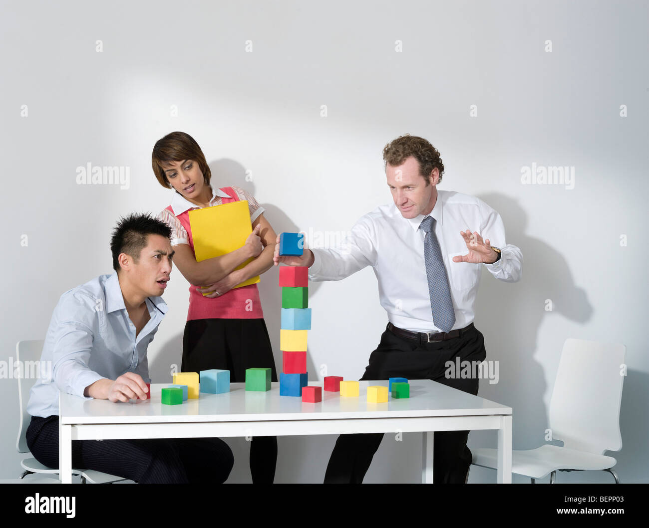 Business-Mann legt letzte Block auf Turm Stockfoto