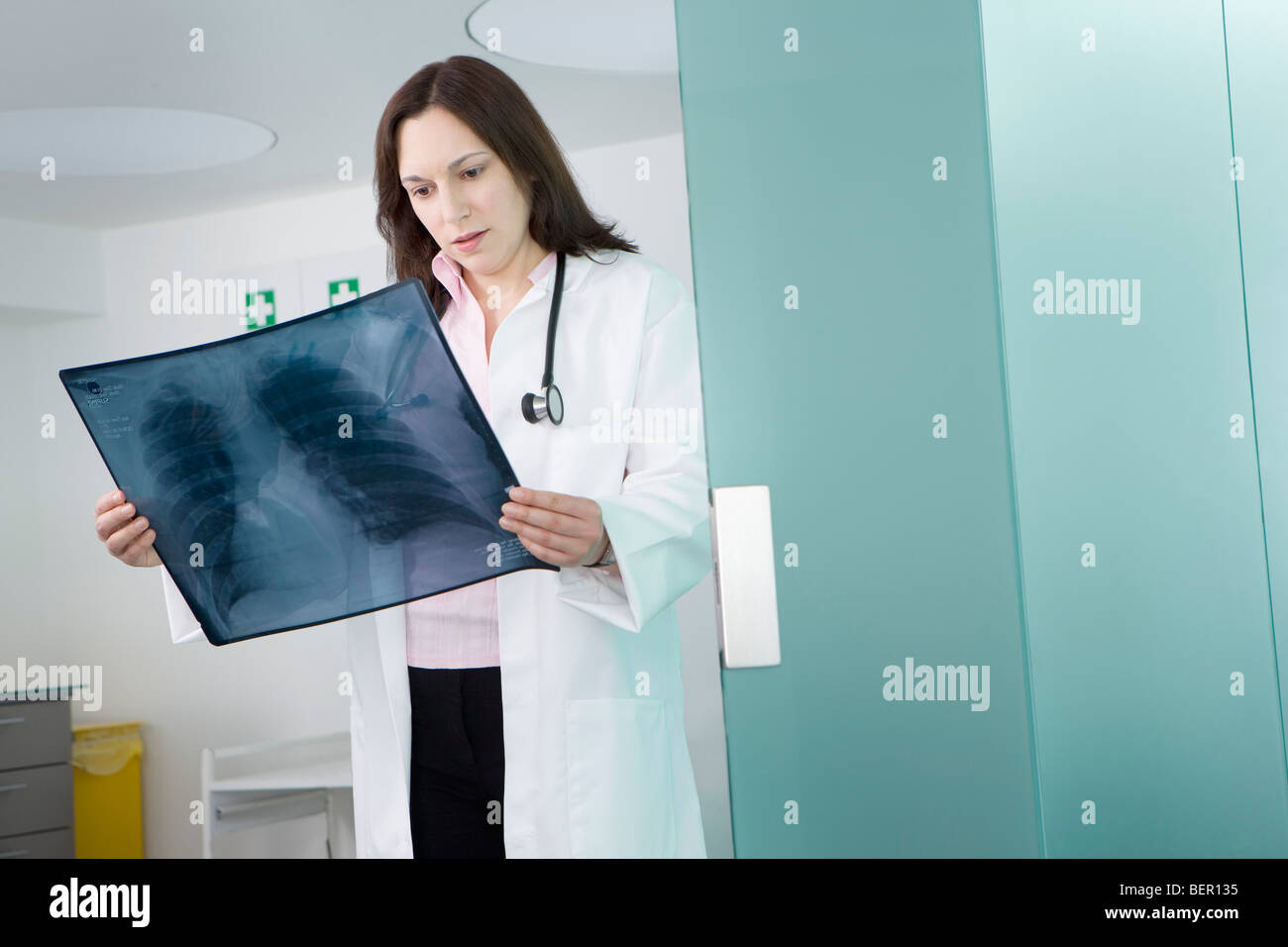 Eine Ärztin, eine Röntgenaufnahme überprüfen Stockfoto