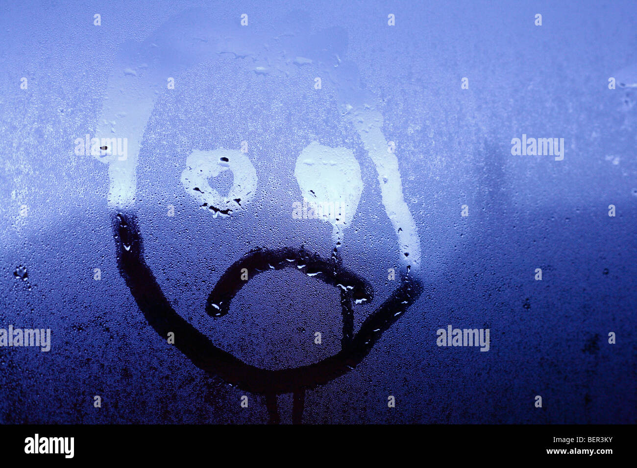 Eine unglückliche kindliches Gesicht auf Fenster Kondensation gezeichnet. Stockfoto