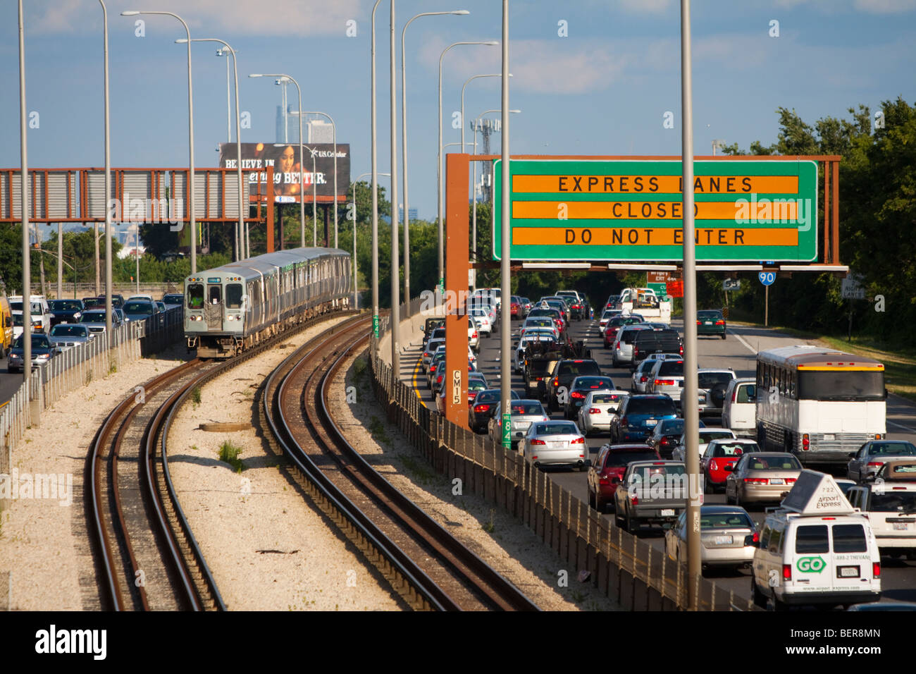 CTA Blue Line L verschiebt sich in der Mitte des Kennedy Expressway als Hauptverkehrszeit, den Verkehr durch kriecht. Stockfoto