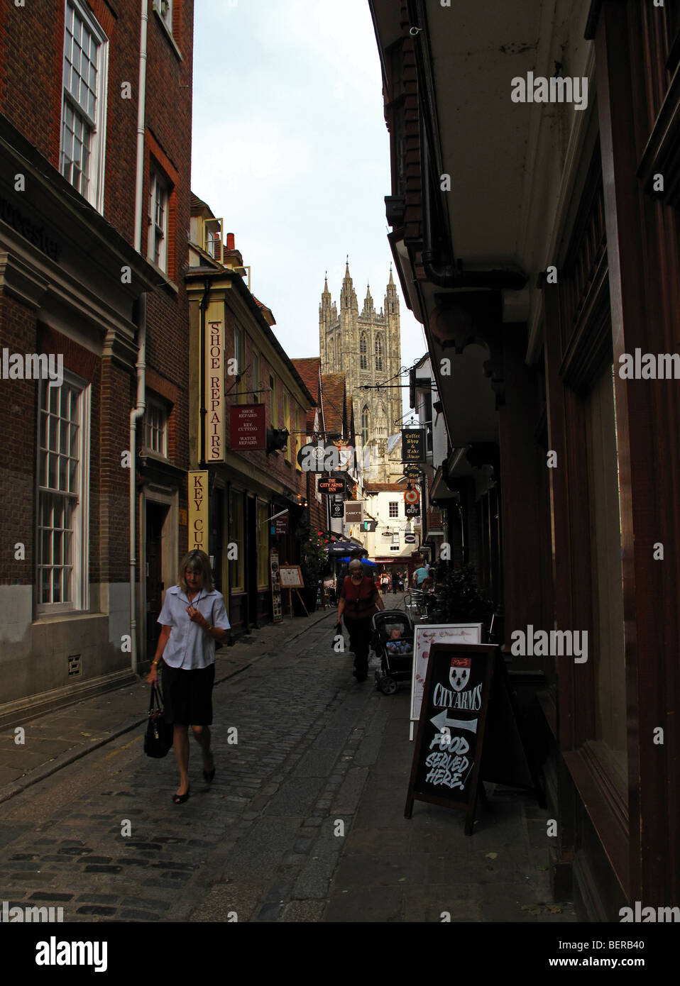 Eine Frau kommt in einer malerischen Straße in Canterbury in Kent, Südengland. Stockfoto