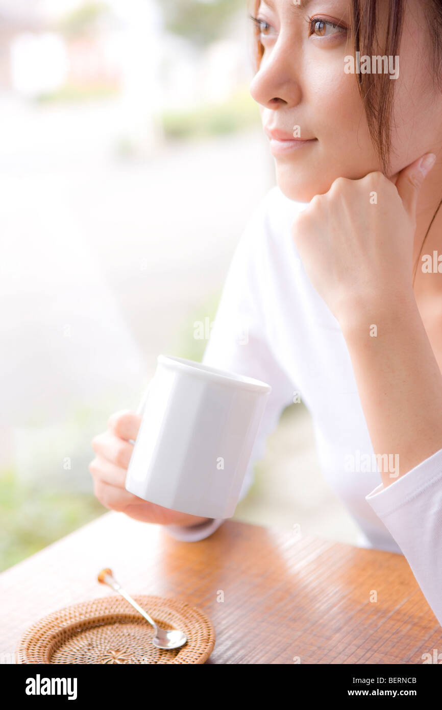 Junge Frau mit Becher in Cafe, Weg suchen Stockfoto