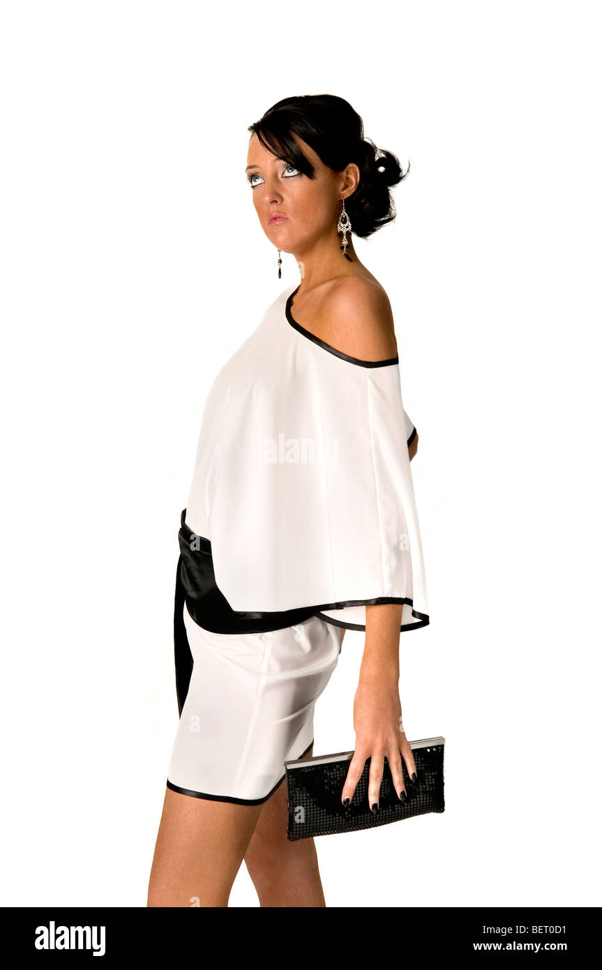 Junge gesunde Frau in schwarzen und weißen Kleid mit schwarzen Clutch-Tasche. VOLL-MODELL VERÖFFENTLICHT Stockfoto