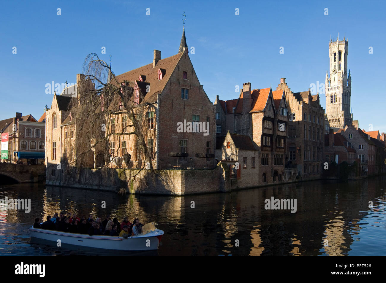 Fahren Glockenturm und Touristen eine Bootsfahrt auf den Kanälen von Brügge, West-Flandern, Belgien Stockfoto