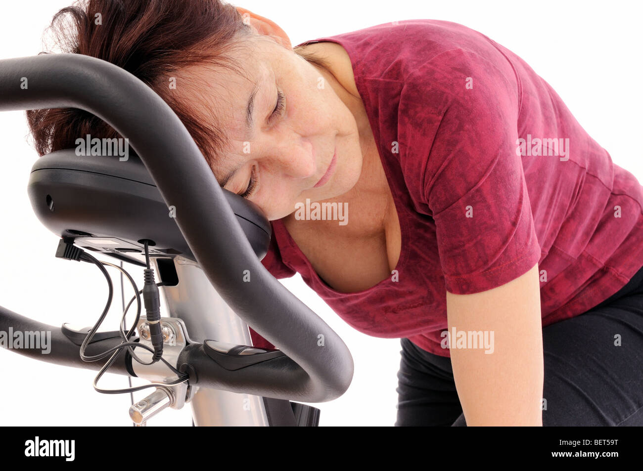 Müde senior Frau auf Spinning Fahrrad - isoliert Stockfoto