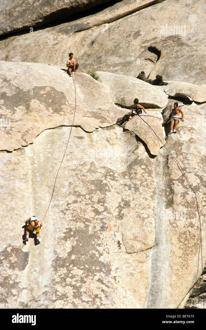 Höhepunkt Ziel Ziel Arbeit Aufwand Kunststück Nervenkitzel Gefahr Bedrohung zu überwinden bis sicher Sicherheit Sonne glühen Himmelblau klar Abseilen Stockfoto