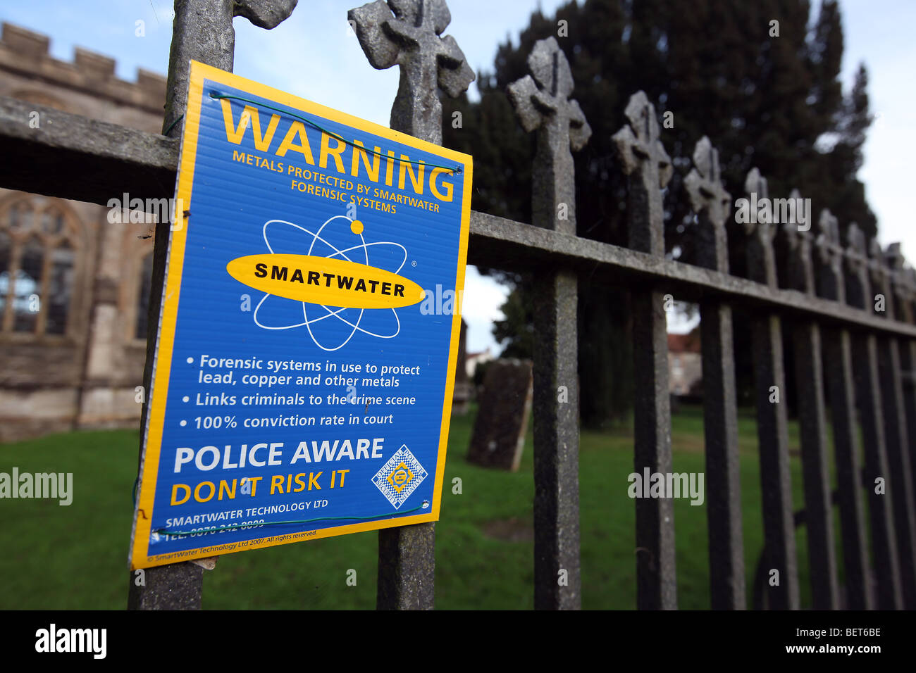 Allgemeines Bild von einem Gusseisen Zaun außerhalb einer Kirche mit einem Smartwater Schild Warnung vor potentiellen Verbrecher. Stockfoto