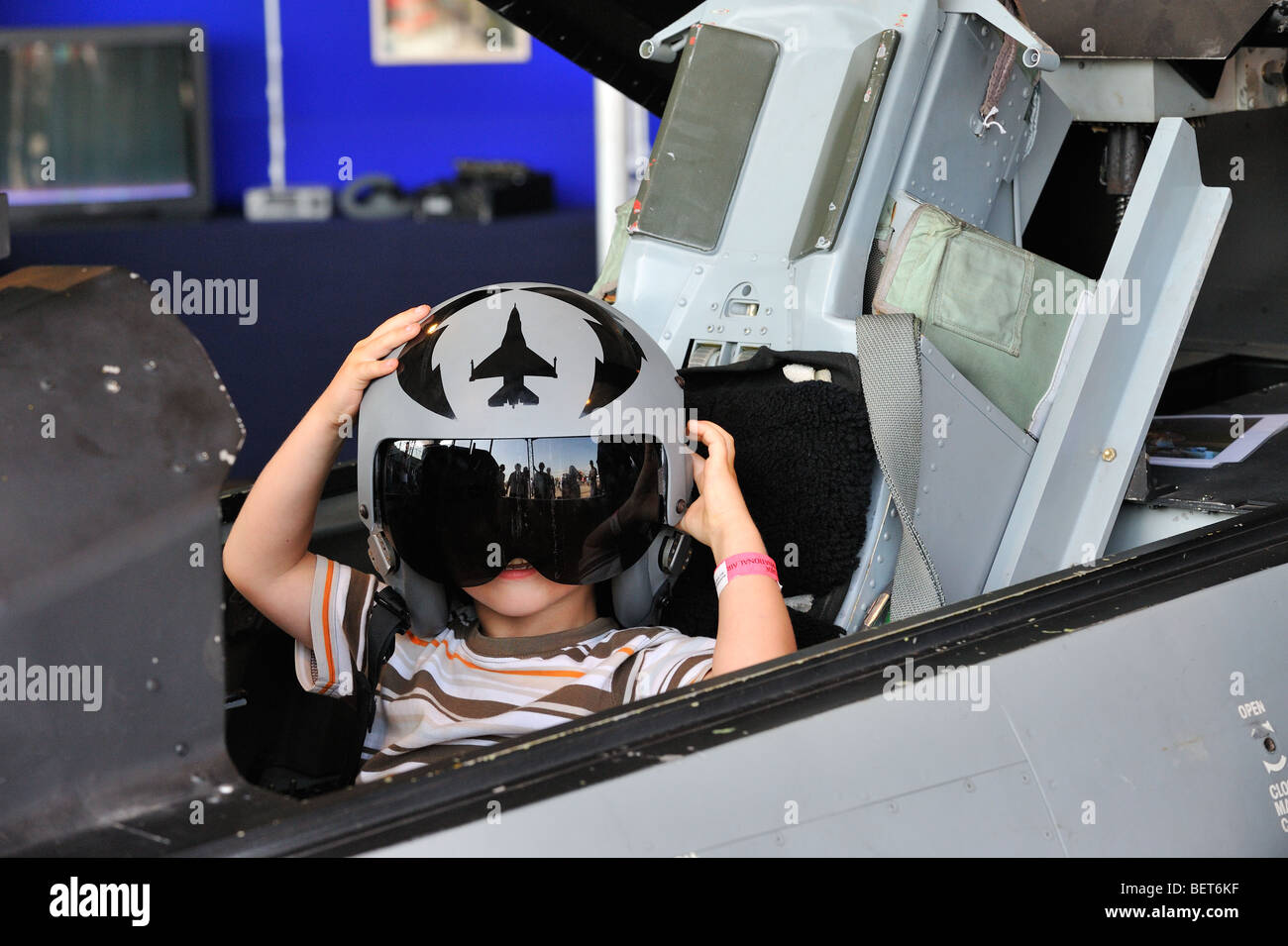 Kind im Cockpit mit Kampfjet-pilot Helm auf Airshow in Koksijde, Belgien Stockfoto