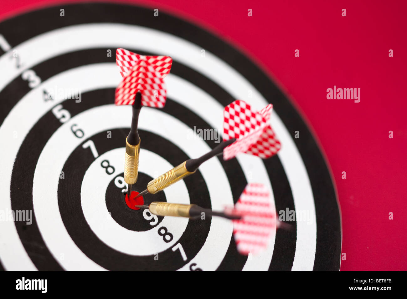 Dartscheibe mit drei Darts im Bullseye, rot und schwarz und weiß Stockfoto