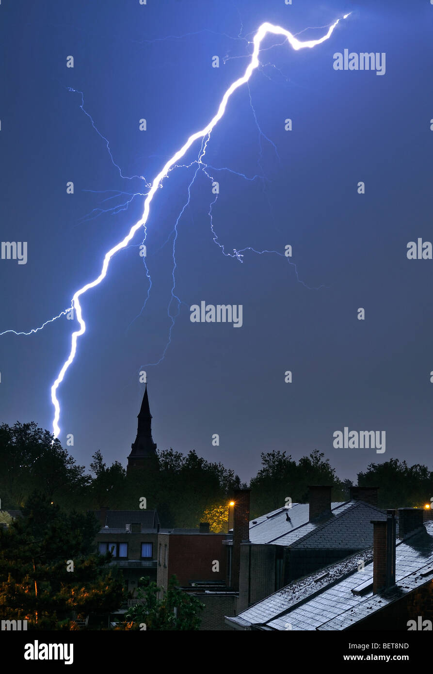 Blitz über Häuser und Kirchturm nachts bei Gewitter Stockfoto