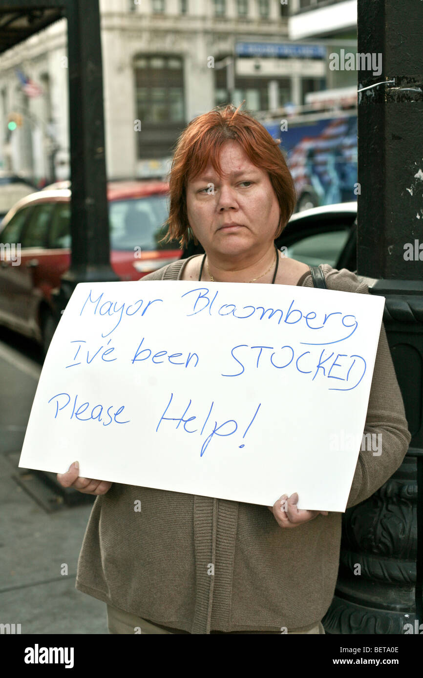 eine bullige elende aussehende Frau mit gefärbten roten Hairholds Hand beschriftet Protest Schild am lower Broadway in der Nähe von Rathaus Stockfoto